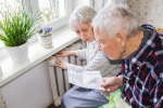 Pensioners looking at bill next to radiator